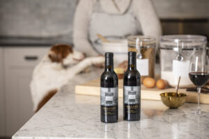 Two bottles of Imagery Port in front of a little dog.
