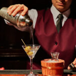 uniformed server pouring a martini at Harris' Steakhouse