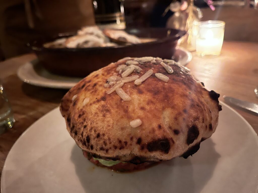beef tartare at Peasant arrives with a toasty cap of pizza dough