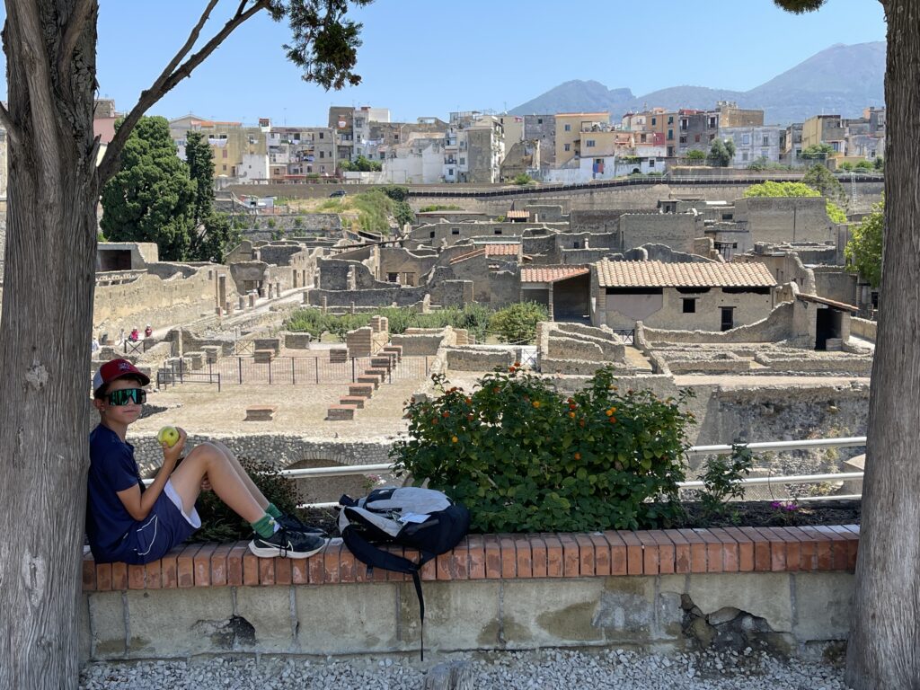 Niki resting at an overlook of Herculaneum with Mount Vesuvius in the background.
