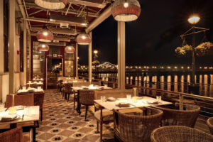 The terrace at Alora restaurant in San Francisco, with Bay Bridge lights in the background.