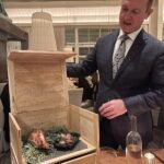 guinea fowl served in a box with the server lifting the lid