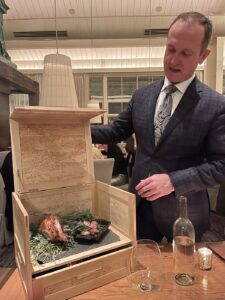 guinea fowl served in a box with the server lifting the lid