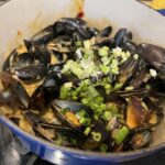 mussels cooking in gochujang curry sauce in my blue Le Creuset