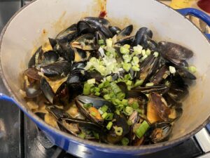 mussels cooking in gochujang curry sauce in my blue Le Creuset