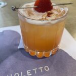 In Bloom tonic cocktail with a strawberry slice on top at Violetto in Napa Valley