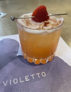 In Bloom tonic cocktail with a strawberry slice on top at Violetto in Napa Valley