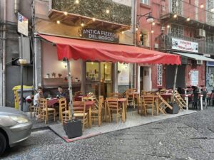 The red awning and outside tables at Antica Pizzeria del Borgo, which was steps from our apartment
