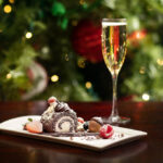 Palace Hotel_Holiday_Yule_Log and a glass of champagne in front of a glittery Christmas tree