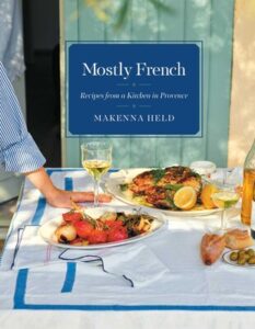 mostly french cookbook cover shows a meal being laid on a linen-clad table, by Makenna Held