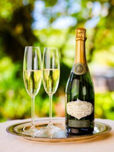 Dry Creek Vineyard Sparkling Chenin Blanc bottle next to two glasses of wine