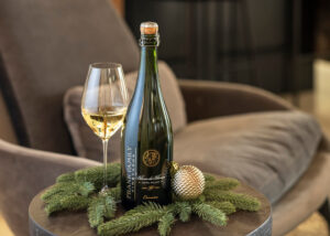 Frank Family Blanc de Blancs sparkling wine in front of a chair with a pine garland