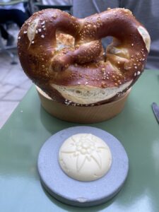 hosemade pretzel on a stand next to fermented butter stamped with an edelweiss at Lindenhof Keller restaurant in Zurich