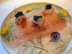 hamachi topped with blood orange and caviar on a chilled pink salt block