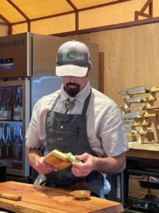 Chef working with fresh wasabi and a rack of knives in the background at Wild Coast Sushi at Treebones, Big Sur