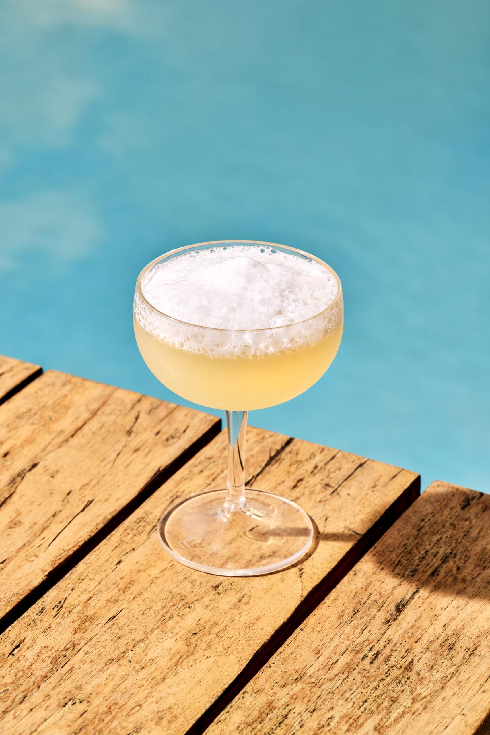 salt air margarita atop wood blanks (a dock?) with a blue sea background