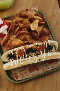 dressed hot dog with chips at The River Electric