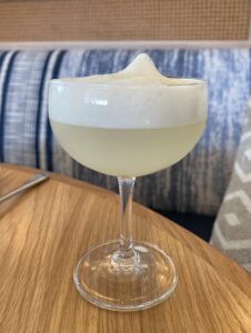 margarita with a foamy top layer on a wood table