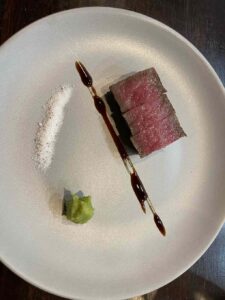 A piece of A5 Wagyu, a stripe of tare, a spritz of salt, and fresh wasabi at Yuji, San Francisco restaurant