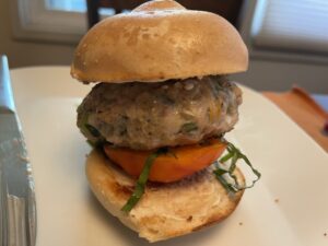 chicken burger on a slider bun with tomato and fresh basil