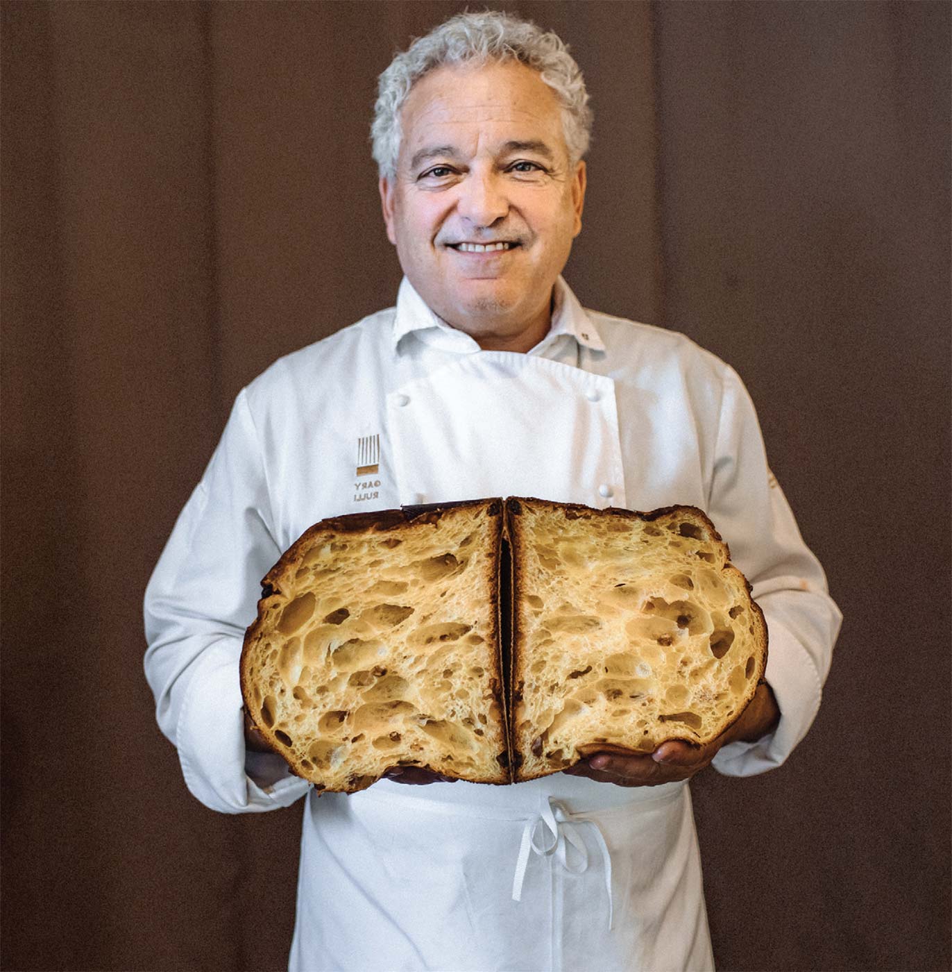 Pastry Chef Gary Rulli of Emporio Rulli in Larkspur holding his signature lofty panettone