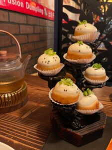 pan-fried pork bao on a tiered tray -- they look like cupcakes