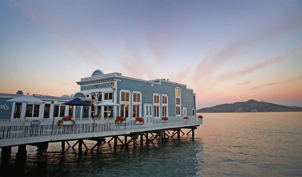 scoma restaurant in sausalito as the sun sets in the background