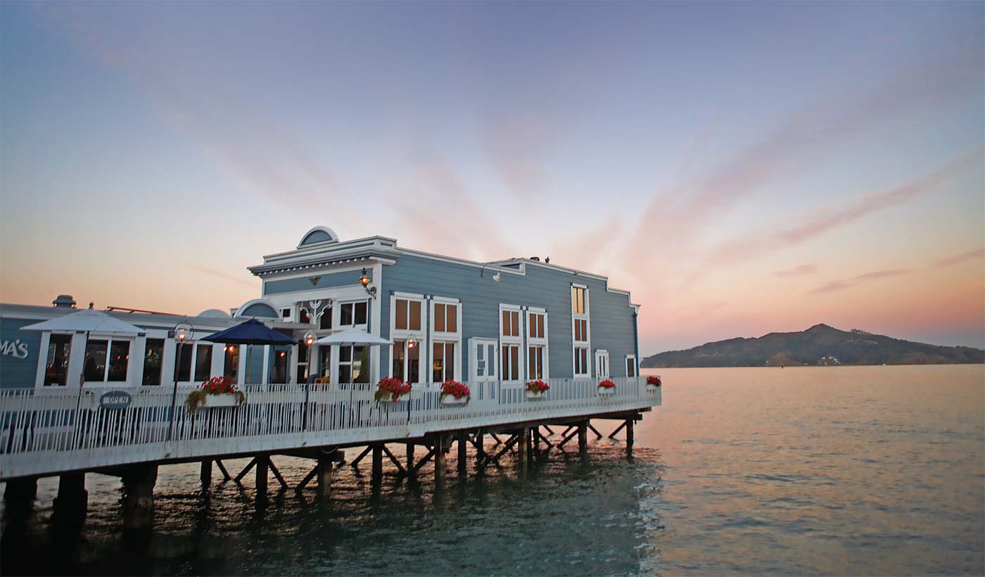 scoma restaurant in sausalito as the sun sets in the background