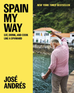 cover image of Spain My Way cookbook by José Andrés shows the chef pouring cider from a bota into a glass