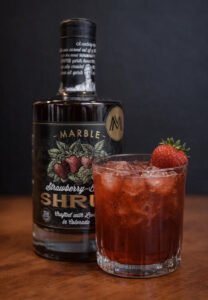 Marble Distilling strawberry balsamic shrub and a non-alcoholic cocktail with a strawberry