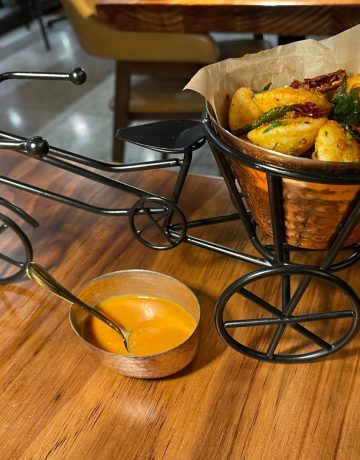 Idli (fluffy fermented rice and lentil dumplings) are served in the wire basket of a wire bike sulpture at Emeryville's, Pippal restaurant
