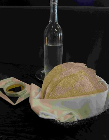 a water bottle, dish of olive oil, and bread basket with gluten-free papadums are just one option at La Toque, one of many gluten-free restaurants.
