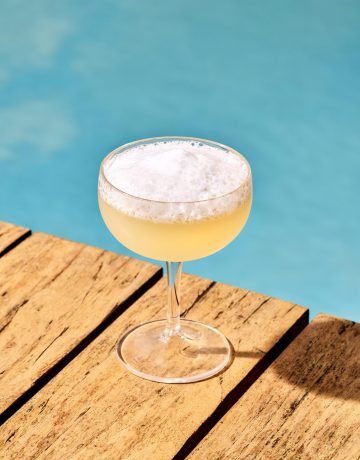 salt air margarita atop wood blanks (a dock?) with a blue sea background
