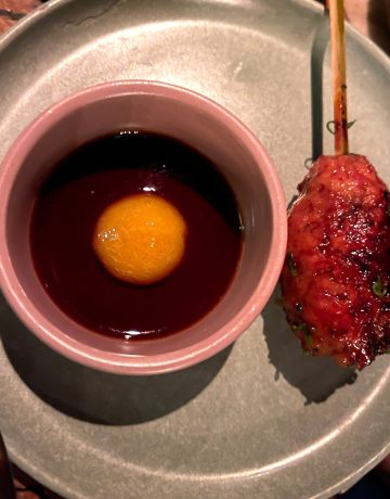 overhead image of a tsukune chicken skewer with egg yolk tare